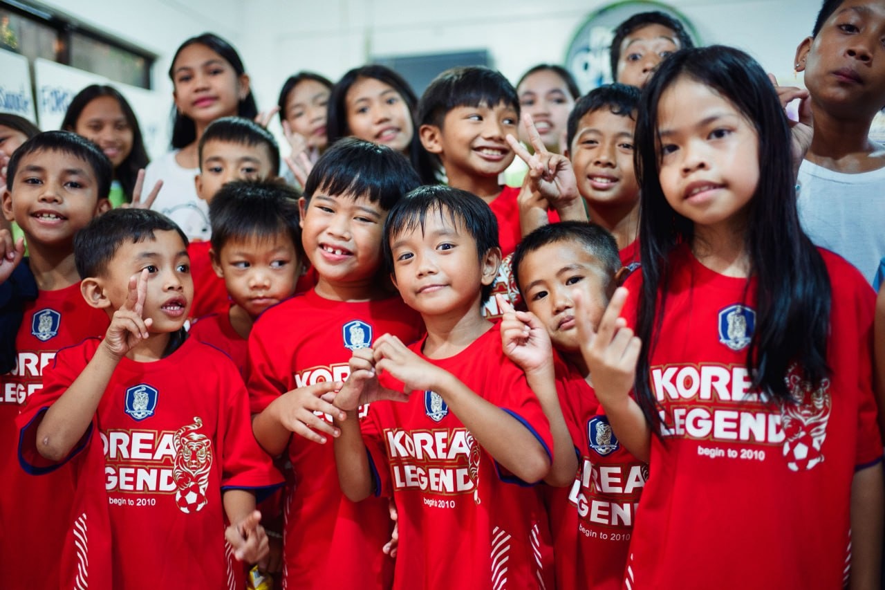 Children at the Manila Children’s Hope Center gather closely together and smile for the camera.